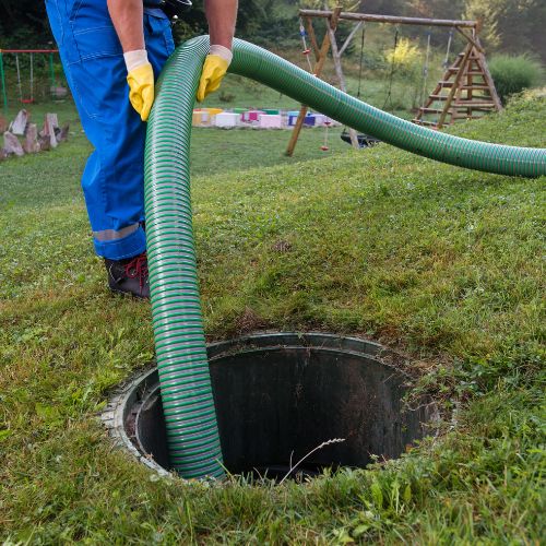 Champion Septic Tank technician performing routine maintenance on a residential septic system.